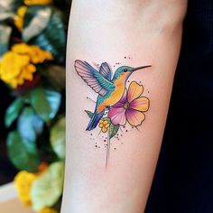 a hummingbird with flowers on its arm