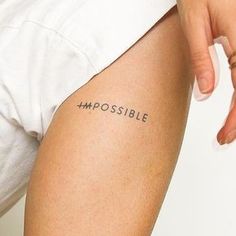 a woman's leg with the word impossible written on it and her left arm