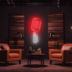 a room with two chairs and a table in front of a neon sign on the wall