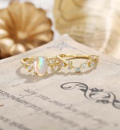 two opal rings sitting on top of a piece of paper next to a pumpkin