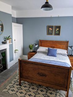 a bedroom with a bed, fireplace and pictures on the wall