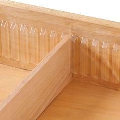 the corner of a wooden bed with clear plastic covering