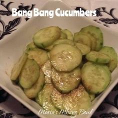 a white bowl filled with cucumbers on top of a table