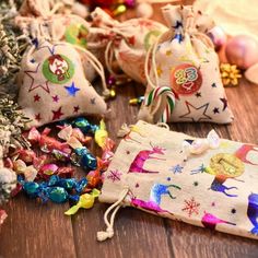 small bags filled with christmas decorations on top of a wooden floor next to a tree