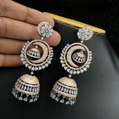 These stylish Rose Gold American Diamond Long Jhumka earrings are the perfect blend of modern and traditional, featuring a classic Chandbali style adorned with black rose gold and a crescent moon dangle. The carefully crafted design is sure to make a statement. Length Of the Earrings 3.25 Inches. Long Jhumka Earrings, Jhumka Designs, Rose Noir, Crescent Moon Earrings, Fancy Jewellery, Jhumka Earrings, Cz Jewelry, American Diamond, Moon Earrings