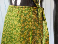 Vintage silk wrap skirt in lovely spring green with yellow flowers. Has a contrasting underskirt.  Dimensions: Waist flat: 46 Inches. Length: 32 Inches. Made in India Green Floral Print Skirt For The Beach, Green Bohemian Wrap Sarong, Traditional Summer Beach Wrap Skirt, Silk Beach Skirt For Summer, Green Bohemian Wrap Skirt For Spring, Traditional Green Summer Skirt, Traditional Green Skirt For Spring, Bohemian Silk Wrap Skirt For Summer, Traditional Silk Skirt For Summer