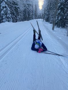 a person laying on their back in the snow with skis attached to their feet