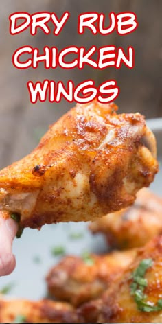 a hand holding up a piece of chicken wings with the words dry rub chicken wings above it