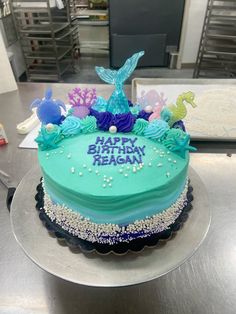 a birthday cake with blue frosting and sea creatures on it