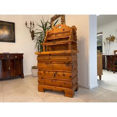 a tall wooden dresser sitting in the middle of a room