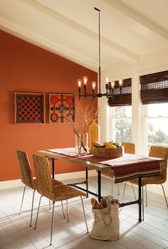 a dining room with orange walls and white tile flooring that has chairs around the table