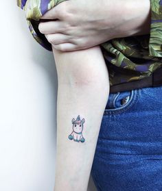 a small unicorn tattoo on the left arm