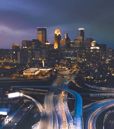 an aerial view of a city at night with cars driving on the road and street lights