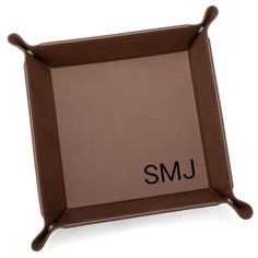 a brown leather photo frame with the word smj in black ink on it's side