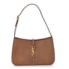 This is an authentic SAINT LAURENT Calfskin Lizard Embossed LE 5 A 7 Hobo in Brown. This elegant shoulder bag is crafted of embossed calfskin leather in brown. The bag features an adjustable shoulder strap. The front features a gold prominent YSL monogram cross strap that opens to a leather interior with a zipper pocket. Elegant Formal Embossed Shoulder Bag, Formal Rectangular Shoulder Bag With Engraved Logo, Elegant Formal Shoulder Bag With Engraved Logo, Formal Embossed Shoulder Bag, Elegant Engraved Shoulder Bag, Luxury Brown Engraved Bags, Elegant Engraved Rectangular Shoulder Bag, Luxury Brown Embossed Shoulder Bag, Elegant Engraved Brown Bags