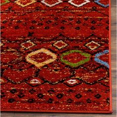 a red area rug with various colors and designs