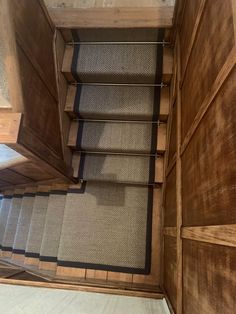 the stairs are made from wood and have carpeted treads on each one side