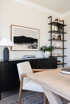 a room with a table, chair and bookshelf