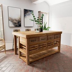 a large wooden table sitting on top of a brick floor next to a chair and potted plant