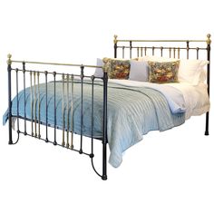 a metal bed frame with blue sheets and pillows on top of it, against a white background