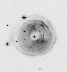 a black and white photo of the center of a circular object with stars around it