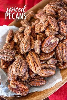 a plate full of sugared pecans sitting on top of a red table cloth