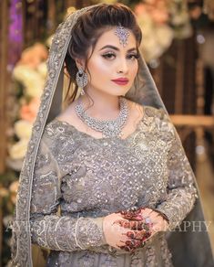 a woman wearing a bridal outfit and jewelry