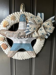 a welcome sign hanging on the front door with seashells and starfish decorations