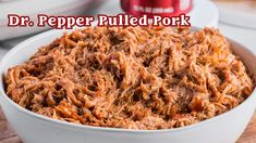 a white bowl filled with pulled pork on top of a wooden cutting board next to other food items