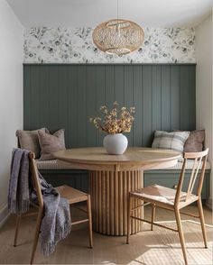 a dining room table with two chairs and a bench in front of the wall behind it