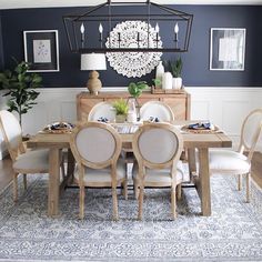 a dining room table with white chairs and blue walls