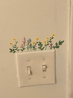 a light switch with flowers painted on it