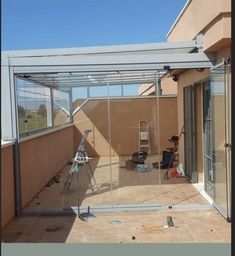 an enclosed patio with sliding glass doors and tiled flooring on the side of a building