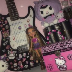 a hello kitty doll next to a guitar and other items