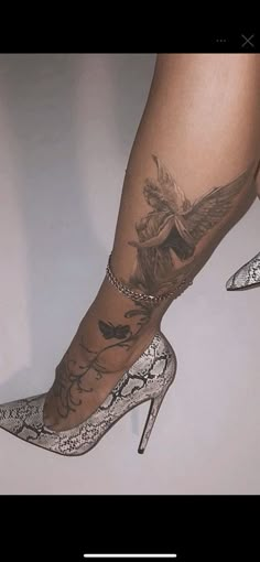 a woman's legs with tattoos and high heels