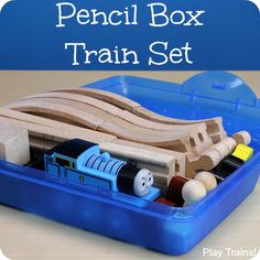 a wooden train set sitting in a blue plastic container with the words pencil box train set on it