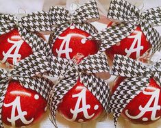 red and black ornaments with the letter a on them are arranged in a basket for display