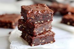 three pieces of chocolate brownie stacked on top of each other with nuts in the middle