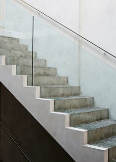 a man riding a skateboard down the side of a set of stairs next to a hand rail