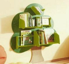 a green tree shaped shelf with books on it