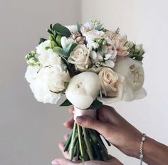 a person holding a bouquet of flowers in their hand