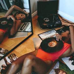 a woman laying on the floor in front of a mirror with an old record player