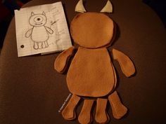 a stuffed animal is sitting on top of a table next to a piece of paper