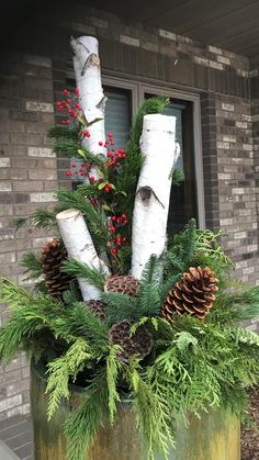 a planter filled with pine cones and evergreens