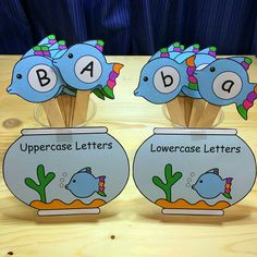 three fishbowes with letters and numbers on them sitting in front of a wooden table