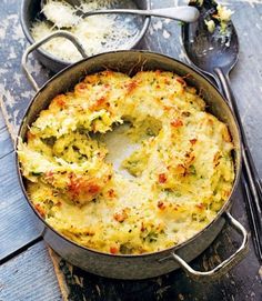 a casserole dish with broccoli and cheese in it on a wooden table