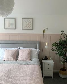 a bedroom with pink and white decor on the walls, bedding and nightstands