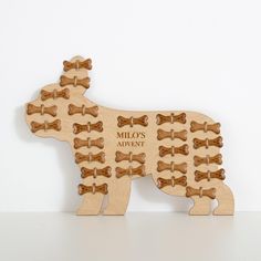 a wooden dog puzzle with lots of bones on it's front and back side