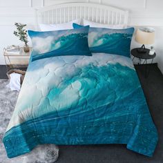 a bed with blue waves on it in a white room next to a night stand