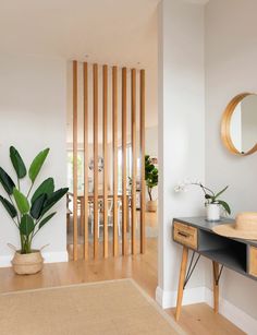 a living room with wooden slats on the wall and a plant next to it